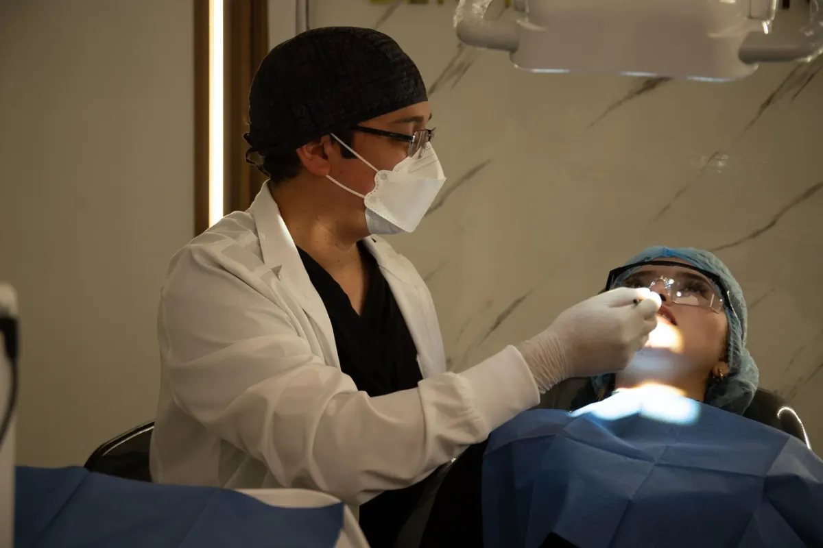 Atención odontológica personalizada en ORALUX Dental Studio, con el doctor atendiendo a una paciente protegida