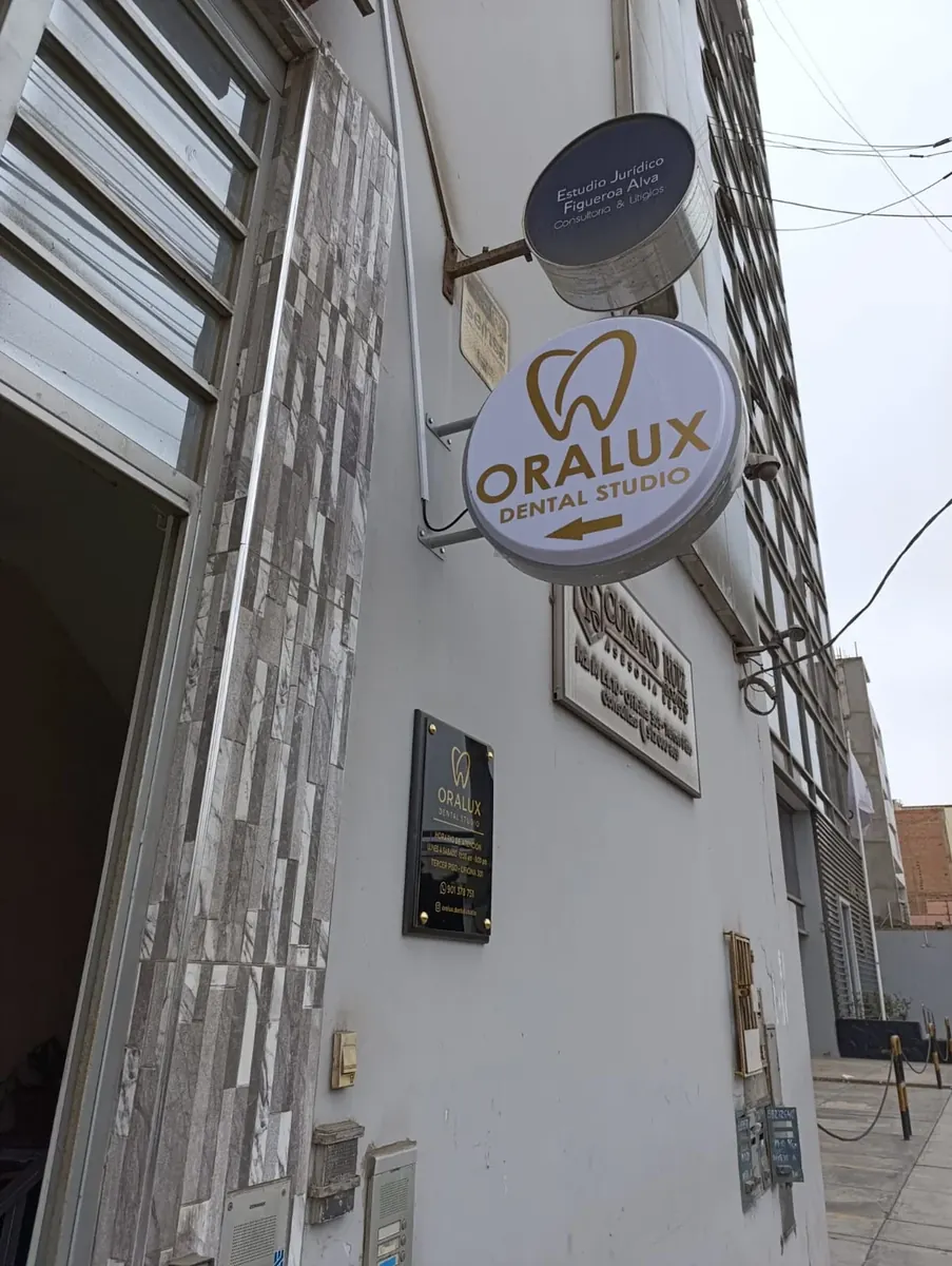 Fachada exterior con letrero redondo de ORALUX Dental Studio